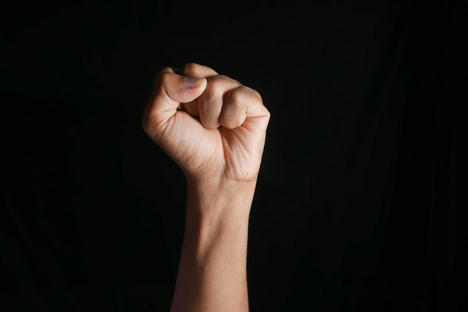 A raised fist against a black background