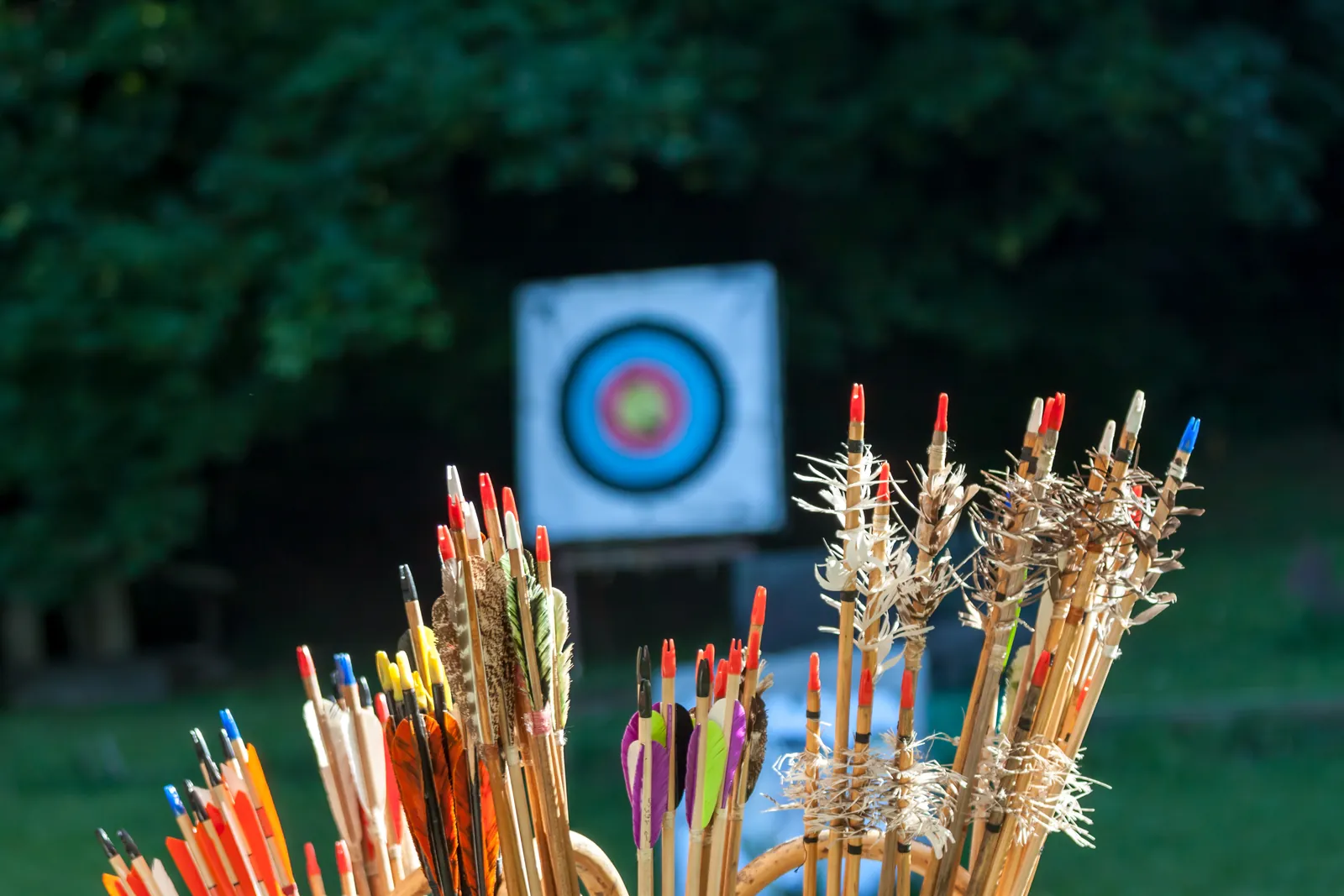 Arrows in a quiver in front of an archery target, representing targeting qualified GMAT test takers