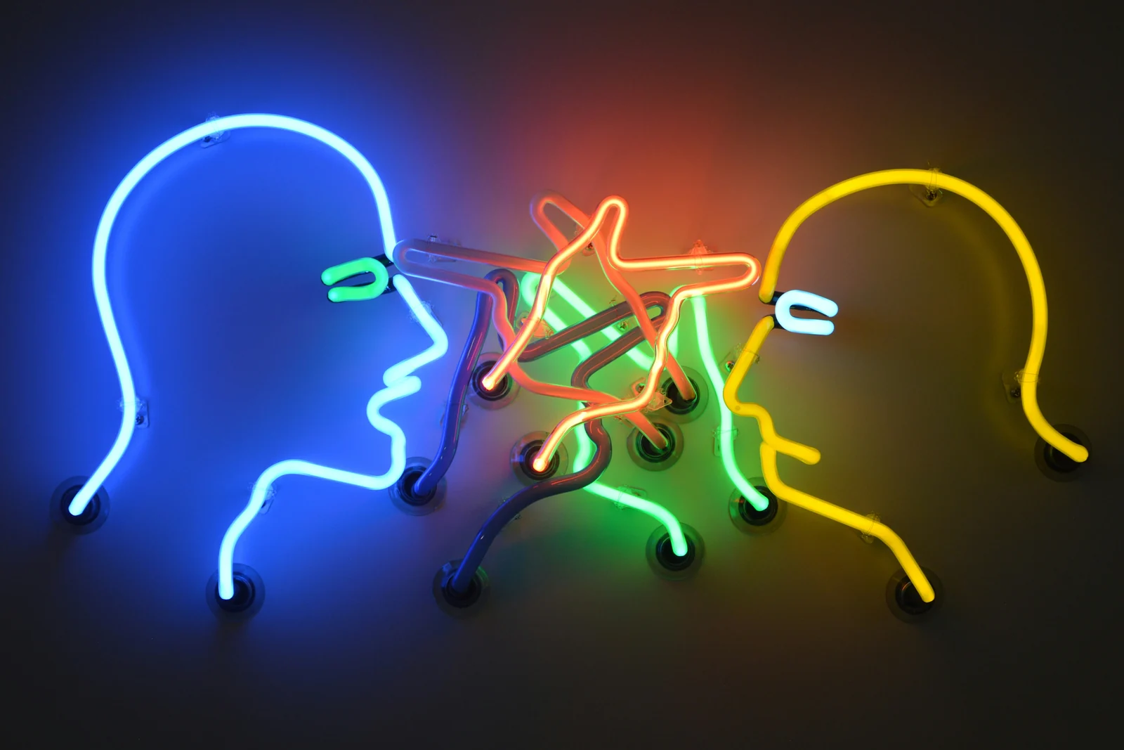 Two neon face profiles meeting, Google Ads and Meta Ads passing the baton