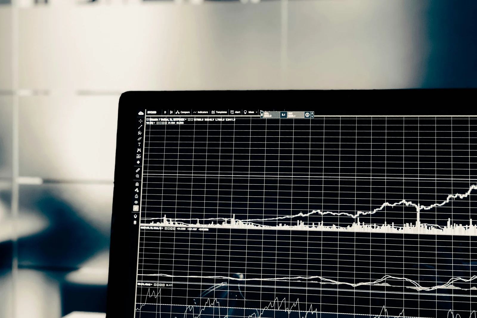 A laptop screen dense with trading charts and indicators in monochrome