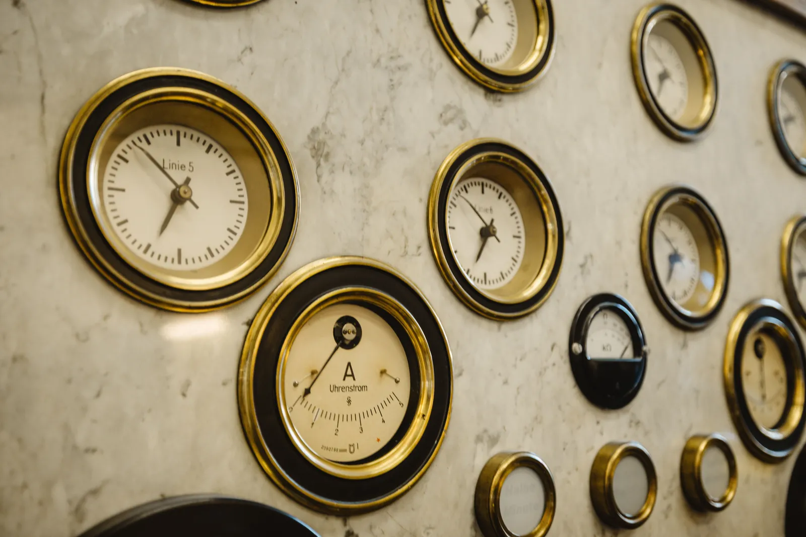 A wall of brass clocks and gauges on marble, representing timing and urgency in advertising copy