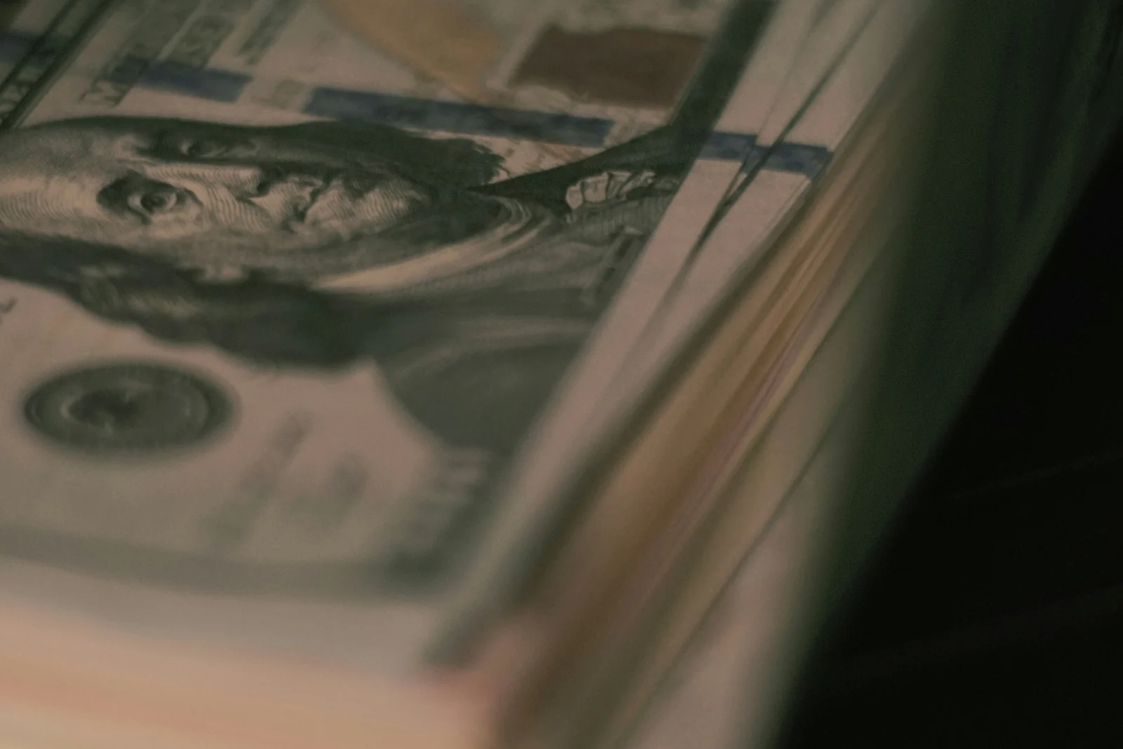 A stack of hundred dollar bills in low light, the return half of a good ROAS calculation