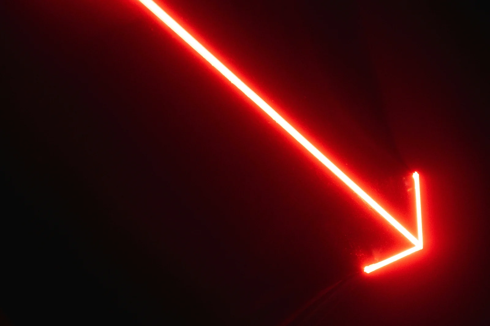 A red neon arrow pointing down, the direction Facebook ads conversions go when the funnel leaks