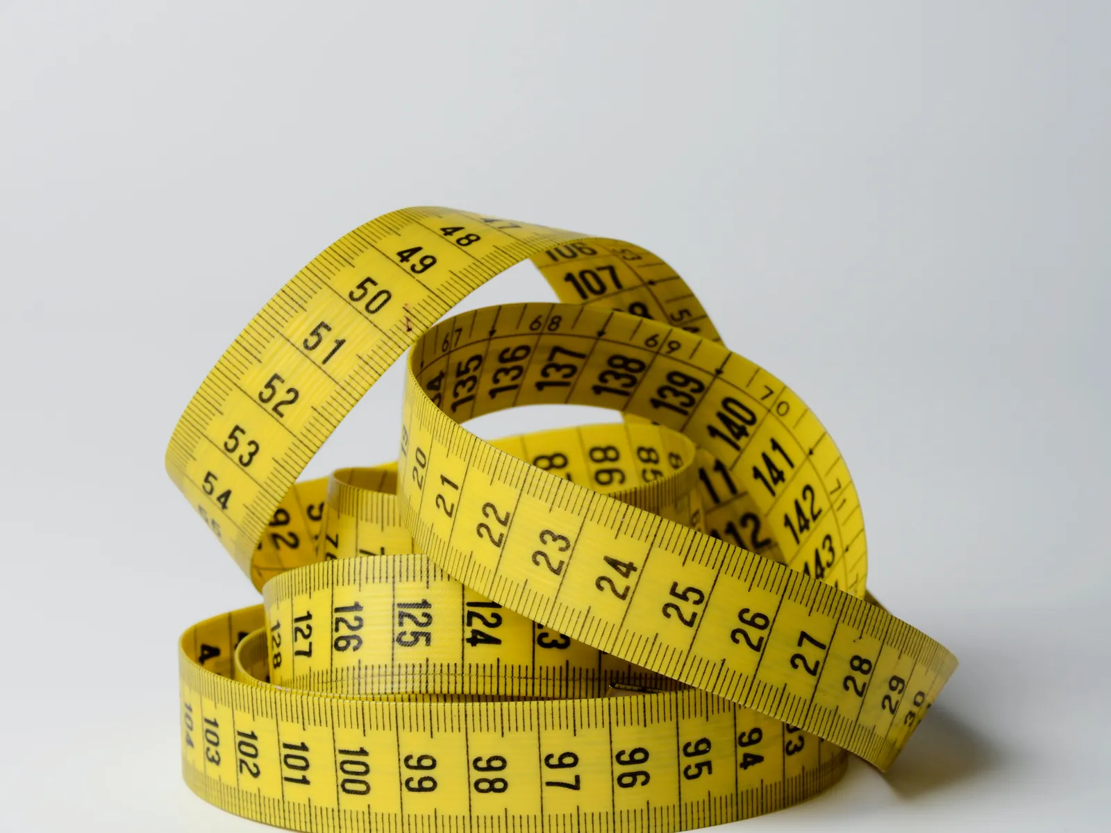 A coiled yellow tape measure, representing healthcare advertising measurement under HIPAA