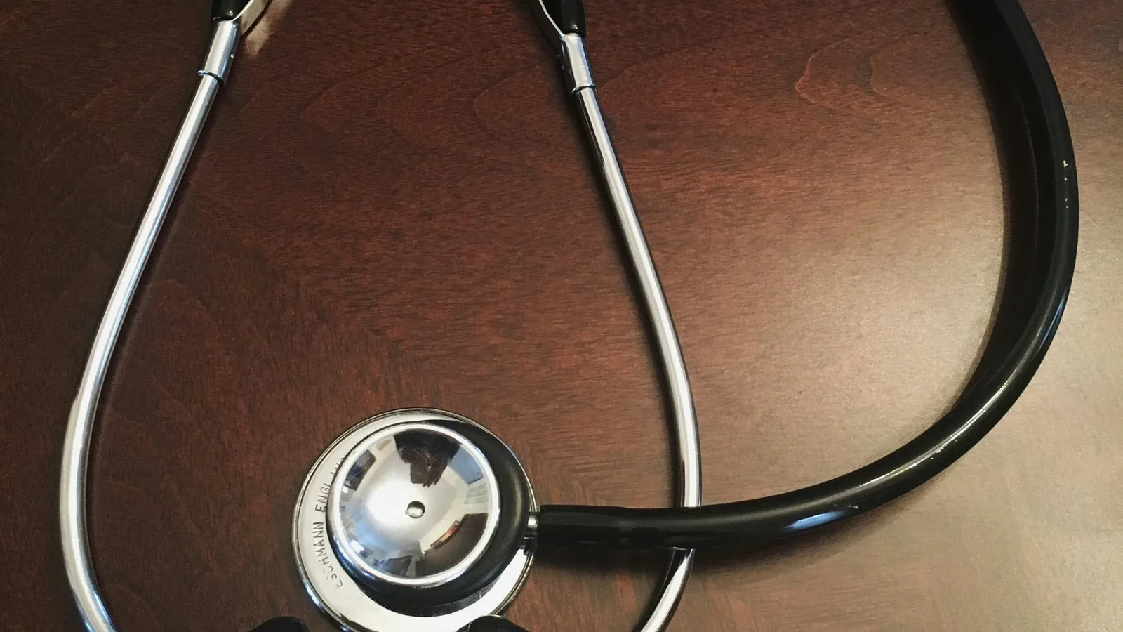 A stethoscope on a dark wooden desk: digital marketing and advertising for pharma, biotech, diagnostics, providers, and health associations