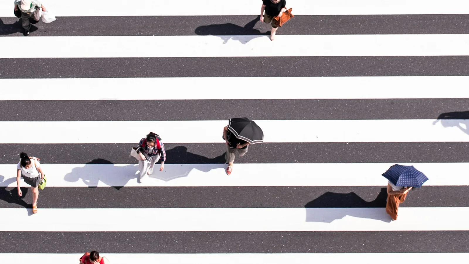 Aerial view of people with umbrellas crossing a striped crosswalk: issue campaigns, coalition work, and reputation defense aimed at Washington