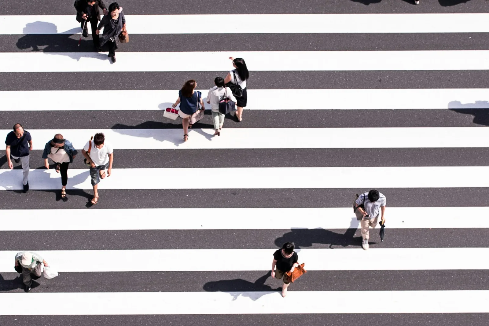 Aerial view of pedestrians crossing a wide striped crosswalk: public affairs and advocacy advertising that reaches policymakers, their staff, and the public where they move